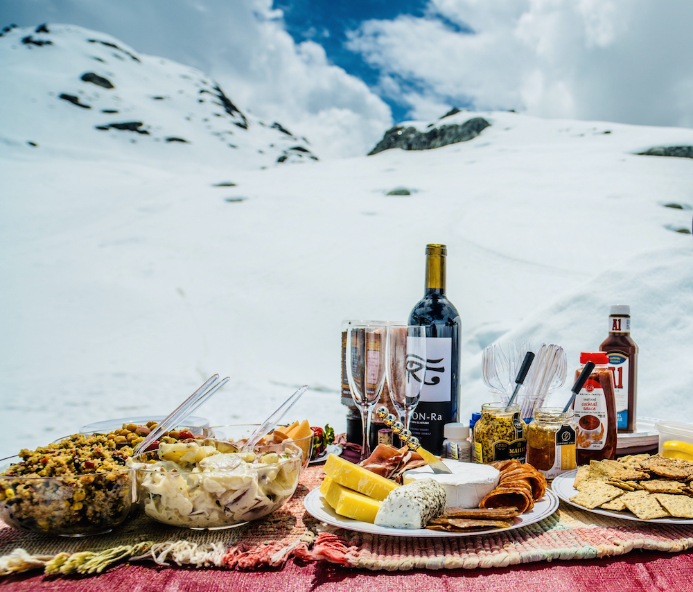 Outdoor picnic table with food and drink in snow at ice cave in British Columbia